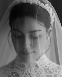 a black and white photo of a woman wearing a veil