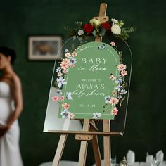 a wooden easel holding a sign with flowers on it