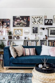 a living room filled with furniture and lots of pictures on the wall above it's bookshelf