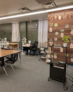 an office filled with desks and chairs next to a wall covered in potted plants