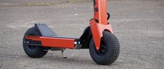 an orange scooter sitting on top of a parking lot