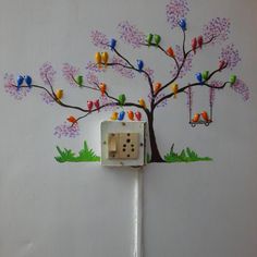 the electrical outlet is decorated with colorful birds and a tree on it's side