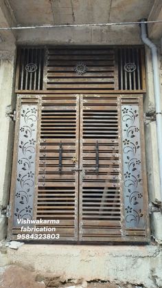 an old building with two wooden doors and iron grills