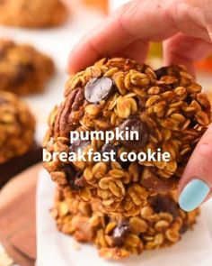 a person holding a cookie in their hand with the words pumpkin breakfast cookie on it