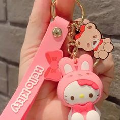 a hello kitty keychain is being held by someone