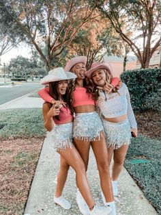 three girls in matching outfits posing for the camera with their arms around each other and smiling