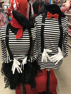 two mannequins dressed in black and white striped shirts with red bow ties