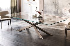 a glass dining table with chairs around it