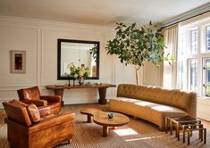 a living room filled with furniture and a large mirror on the wall above it's windows