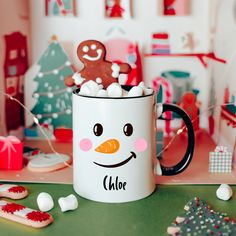 a white coffee mug filled with marshmallows and a gingerbread