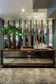 a large mirror in the middle of a room next to a table with plants on it