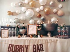 there is a buffet table with balloons on the wall behind it and an old fashioned bar sign