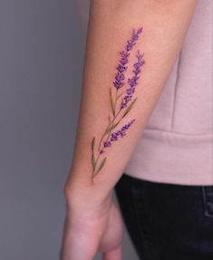 a woman's arm with purple flowers on it