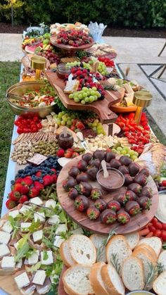 a long table filled with lots of food on top of grass next to a lawn