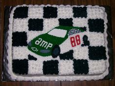 a cake that is decorated with a car on the side and checkerboard pattern