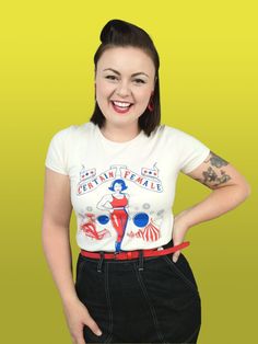 "Hurry! Hurry! Step right up! See the certain female you've all been waiting for! Complete with fairground and big tops, our sideshow strong woman design is screen printed onto 100% natural cotton, giving it that authentic 50's look and feel. \"You Wanna Be Americano?\" Then land an opportunity with this gorgeous garment, which pairs perfectly with dark denim. Designed and finished in the North East of England 100% Cotton Crew Neck  Short Sleeved T-Shirt. This is an original vintage inspired des Fitted Rockabilly Tops With Graphic Print, Rockabilly Graphic Print Short Sleeve Top, Retro Short Sleeve Tops For Retro-themed Events, Fitted Vintage T-shirt With Retro Print, Mode Rockabilly, Rockabilly Mode, Vintage T Shirt Design, 50s Look, Woman Design