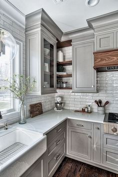 a kitchen with gray cabinets and white counter tops