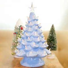 a white ceramic christmas tree sitting on top of a wooden table