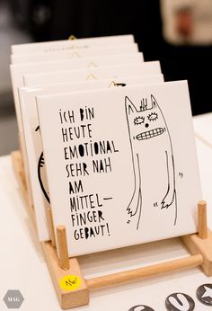 a set of five greeting cards with black and white drawings on them sitting on a wooden stand