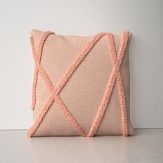 a pink pillow sitting on top of a white table