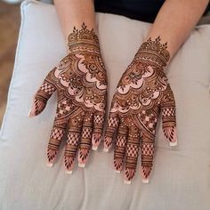 two hands with henna designs on them