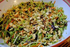 a white bowl filled with lots of veggies and nuts