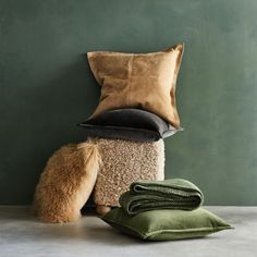 a pile of pillows and blankets sitting next to each other on top of a table