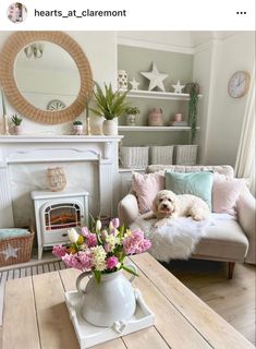 a living room filled with furniture and a dog laying on top of a couch next to a fire place