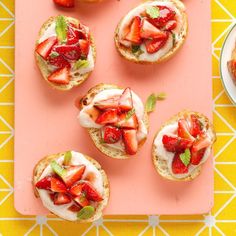 strawberry shortcakes with whipped cream and fresh strawberries on top are arranged on a pink tray