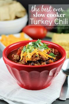 the best ever slow cooker turkey chili in a red bowl on a white napkin