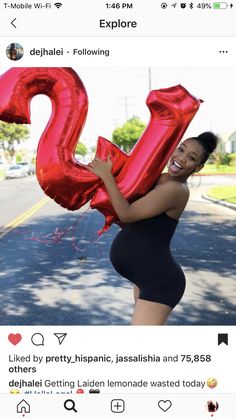 the woman is holding two large red balloons