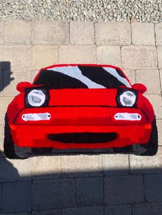 a red car with zebra stripes painted on it's hood is shown from above