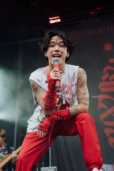 a man in red pants holding a microphone