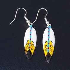 Hand painted bone feather earrings. Native New Mexico made. Tribal jewelry.  2 1/8" X 3/4" which includes the earring hooks Feathers mean a lot to Native American Tribes.  A feather isn't just something that falls out of a bird, it means much more.  The feather symbolize trust, honor, strength, wisdom, power, freedom and many more things. To be given one of these is to be hand picked out of the rest of the men or women in the tribe - it's like getting a gift from a high official. Thank you for y Artistic White Nickel-free Earrings, Southwestern White Teardrop Earrings, Nickel-free White Southwestern Earrings, Traditional Hand Painted White Earrings, Traditional White Hand Painted Earrings, Traditional White Hand-painted Earrings, White Hand Painted Drop Earrings, Indigenous Jewelry, Feather Meaning