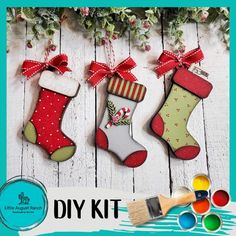 christmas stockings and stockings ornament kits with paintbrushes on white wooden background