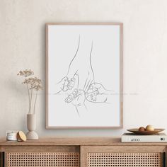 a drawing of two hands holding each other in front of a white wall with books and vases