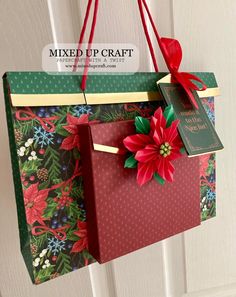 a paper bag hanging from the side of a door decorated with poinsettis