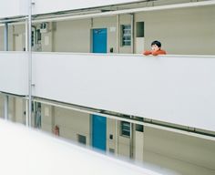 a man standing on the balcony of a building looking at something in the distance behind him