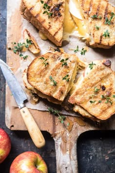 grilled cheese sandwiches on cutting board with apple slices and knife next to each other