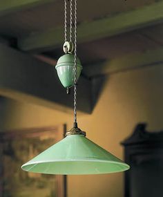 a green light hanging from a ceiling in a room