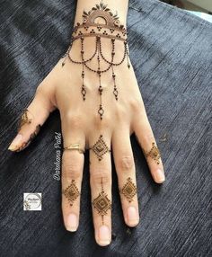 a woman's hand with hennap and jewelry on top of her hands