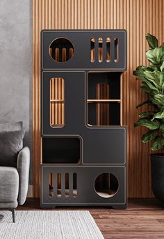 a living room with a gray couch and black bookcase on the floor next to a potted plant