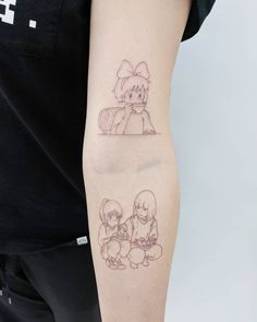 a person with a tattoo on their arm that has two images of anime characters drawn on it