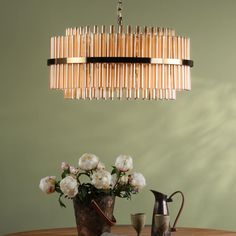 a wooden chandelier hanging over a dining room table with flowers in vases