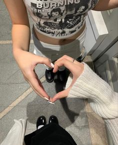 a woman making a heart shape with her hands