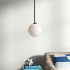 a living room with a couch, chair and lamp hanging from the ceiling above it