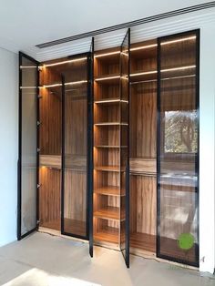 an empty room with wooden shelves and glass doors