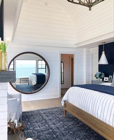 a bedroom with a large bed and a round mirror on the wall