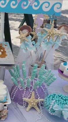 a table topped with cakes and cupcakes covered in frosting next to other desserts