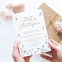 a person holding up a birthday card with butterflies on it